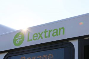 open: lextran logo in green on a white bus with the sun peaking over the top