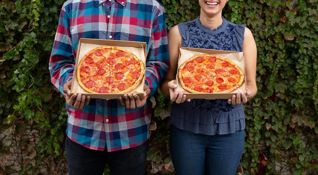 man and woman holding pepperoni pizza in a blaze pizza box