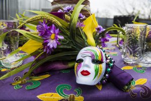 mardi gras mask with purple, yellow, and green and purple flowers