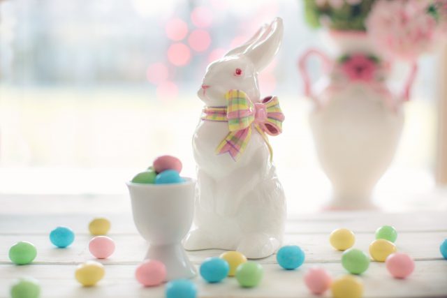 Easter Egg Hunts: small colorful candy eggs in a white porcelin cup and bunny