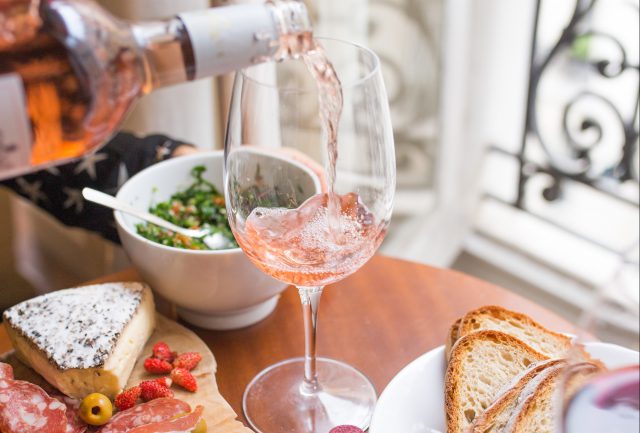 The Summit: Wine being poured into a glass surrounded by food