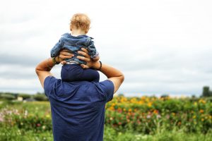 Father's Day: a young boy in a blue shirt on his father's shoulders