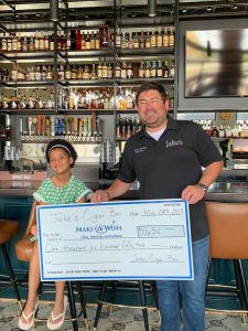 Jake's Cigar Bar: a man and a young girl holding a big check