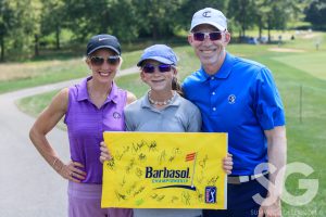 a family holding a yellow flag that says Barbasol and lots of signatures